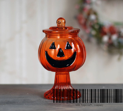 Glass pumpkin candle holder with glass base and glass lid.