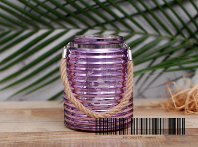 Glass lantern with rope handle and laser design.