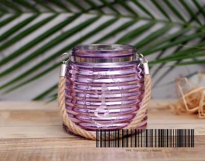 Glass lantern with rope handle and laser design.